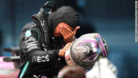 An emotional Hamilton celebrates with his Mercedes team after the race. 