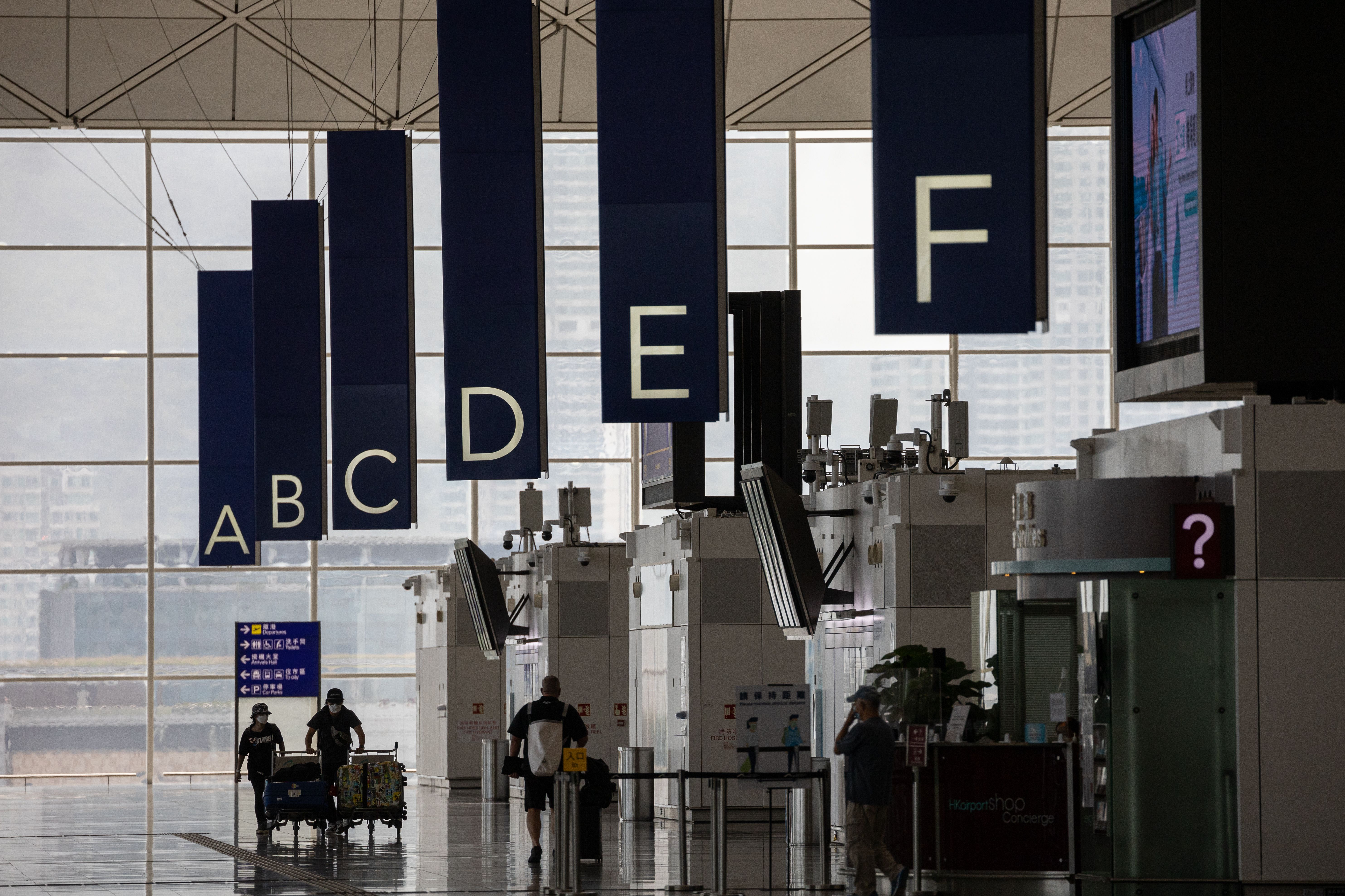 Travelers push their luggage in the departure hall of Hong Kong International Airport on October 19.