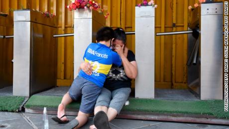 Fans of Boca Juniors cry and hug eachother near La Bombonera.