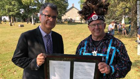 Thomas Kemper, the former general secretary of global ministries for the United Methodist Church, and Wyandotte Nation Chief Billy Friend hold a deed signifying the transfer of land to the tribe.