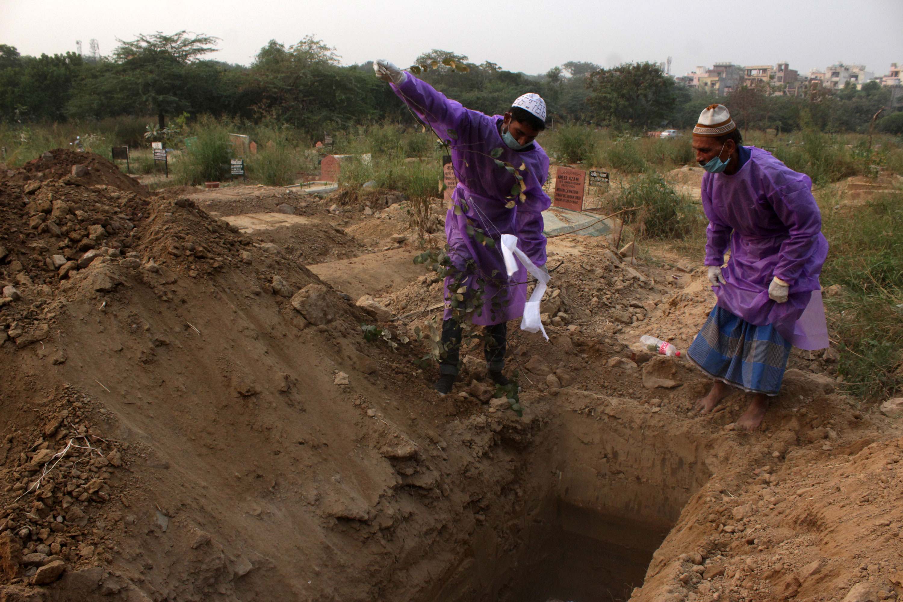 Family members in personal protective equipment perform the burial of a person who died of Covid-19 at a graveyard in New Delhi on November 12.