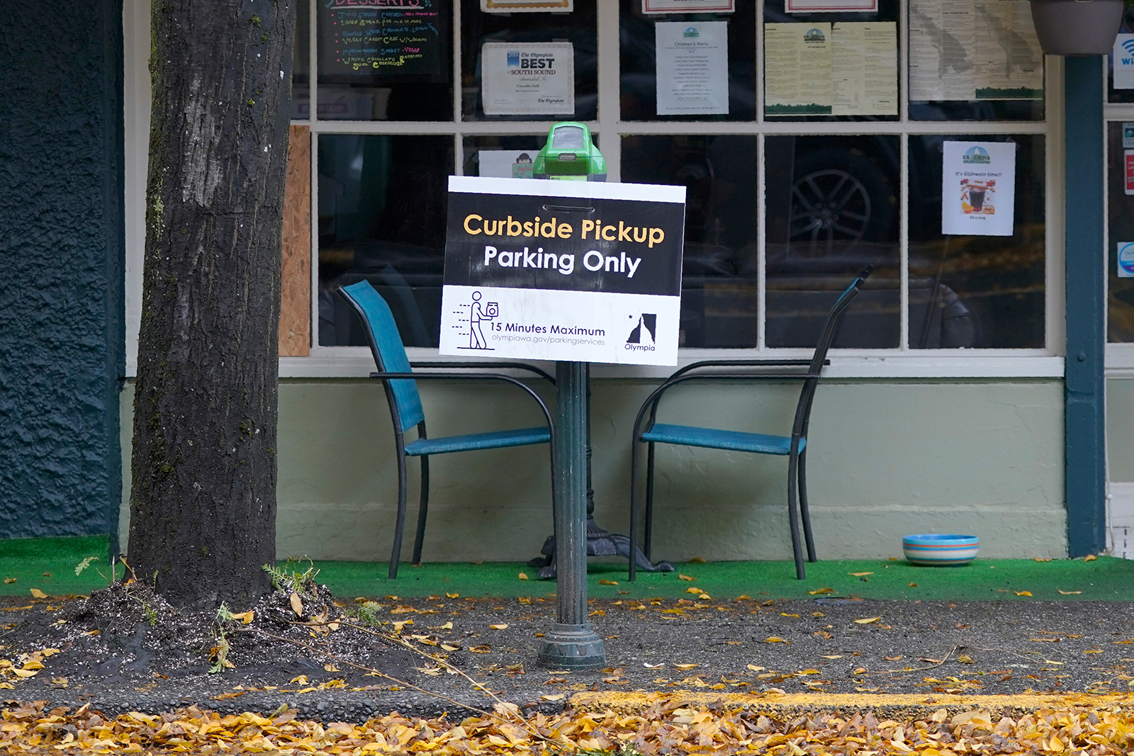 A sign for curbside pickup is shown outside the Cascadia Grill, in downtown Olympia, Washington, on November 15.