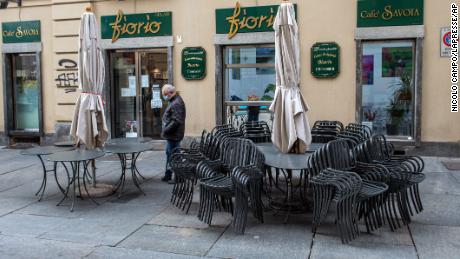 A man wearing a face covering walks past a closed cafe, in Turin, northern Italy, on November 6. On Wednesday, the country registered its highest number of deaths since the first wave of the pandemic.