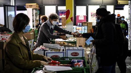 A volunteer at a Restos du Coeur center in Paris hands out food in October.