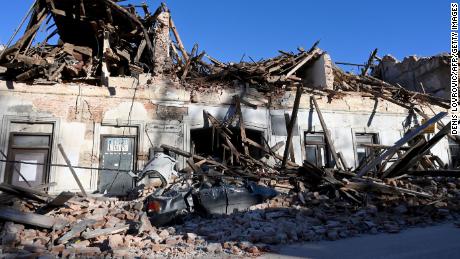 The wreckage of a car and buildings in Petrinja.