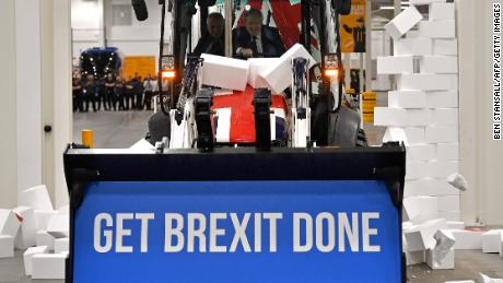 Boris Johnson drives a Brexit-themed JCB through a fake wall emblazoned with the word &quot;GRIDLOCK,&quot; during the 2019 general election campaign.