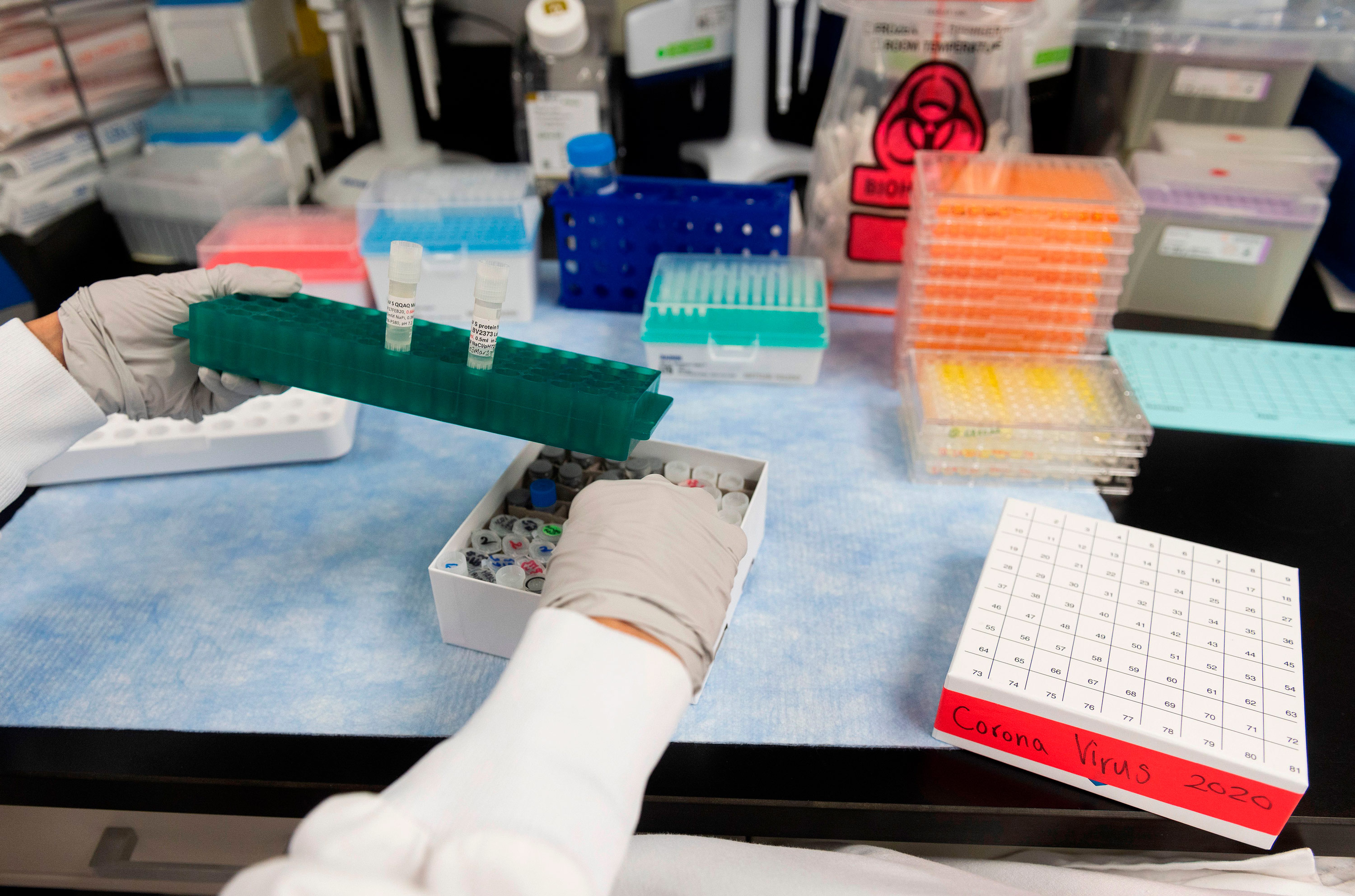 A vial with a potential COVID-19 vaccine is lifted at Novavax labs in Gaithersburg, Maryland on March 20. 