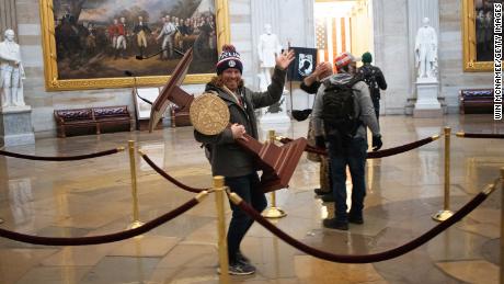 A pro-Trump protester carries the lectern of U.S. Speaker of the House Nancy Pelosi through the Roturnda of the U.S. Capitol Building.