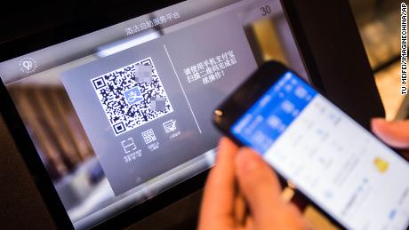 A Chinese man uses an &quot;electronic ID card&quot; in a mobile payment app to check into a hotel in Hangzhou in April 2017. The blurred QR code was not added by CNN.