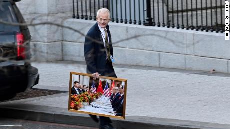 Navarro leaves the West Wing of the White House carrying a framed photograph on Jan 13, 2021. 