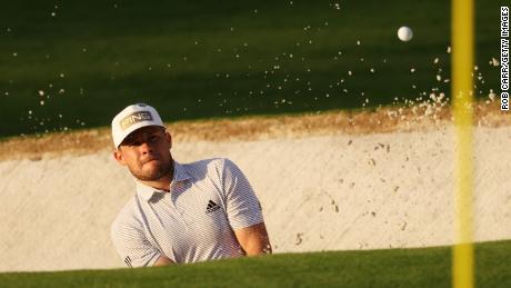 In the first round of the Masters at Augusta Hatton plays a shot out of a bunker. 