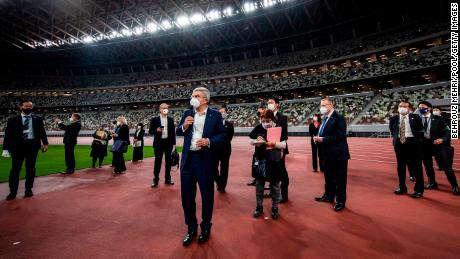 International Olympic Committee President Thomas Bach, wearing a face mask, speaks to the media during a visit to the Japan National Stadium on November 17, 2020 in Tokyo.