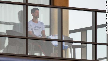 Men&#39;s singles world number one tennis player Novak Djokovic of Serbia sits on his hotel balcony in Adelaide, Australia, on January 18, one of the locations where players have quarantined for two weeks upon their arrival ahead of the Australian Open tennis tournament in Melbourne.