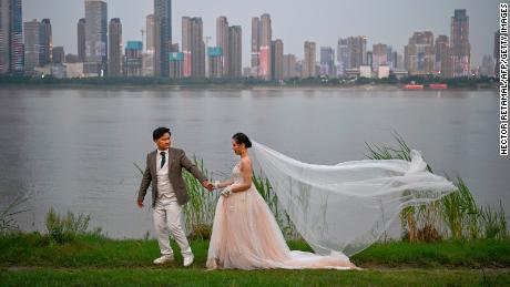 A couple poses during a wedding photo shoot next to Yangtze River in Wuhan, China.