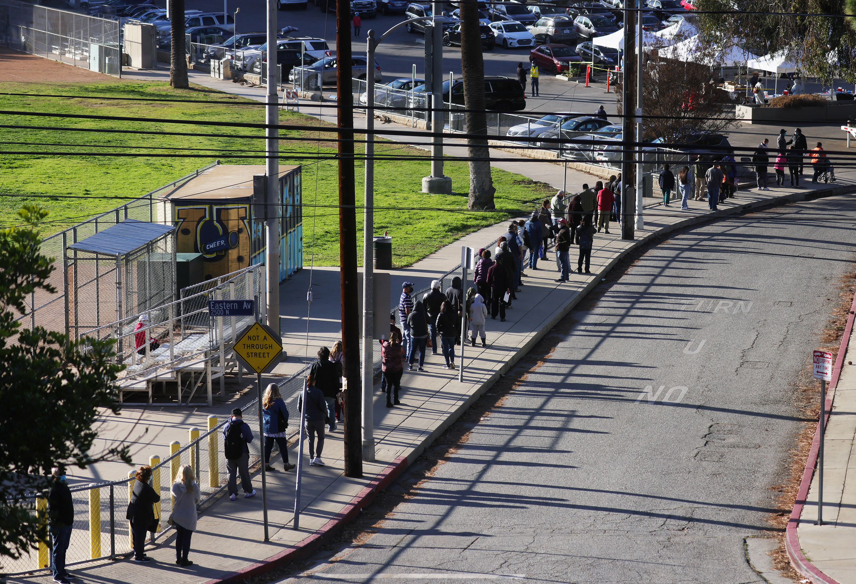 People with appointments wait in line to receive the COVID-19 vaccine at a walk-up public health vaccination site on Tuesday, January 26, in Los Angeles.