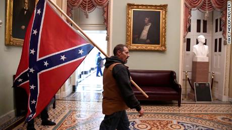 A supporter of President  Trump carries a Confederate battle flag on the second floor of the U.S. Capitol after breaching security defenses, on January 6, 2021.    