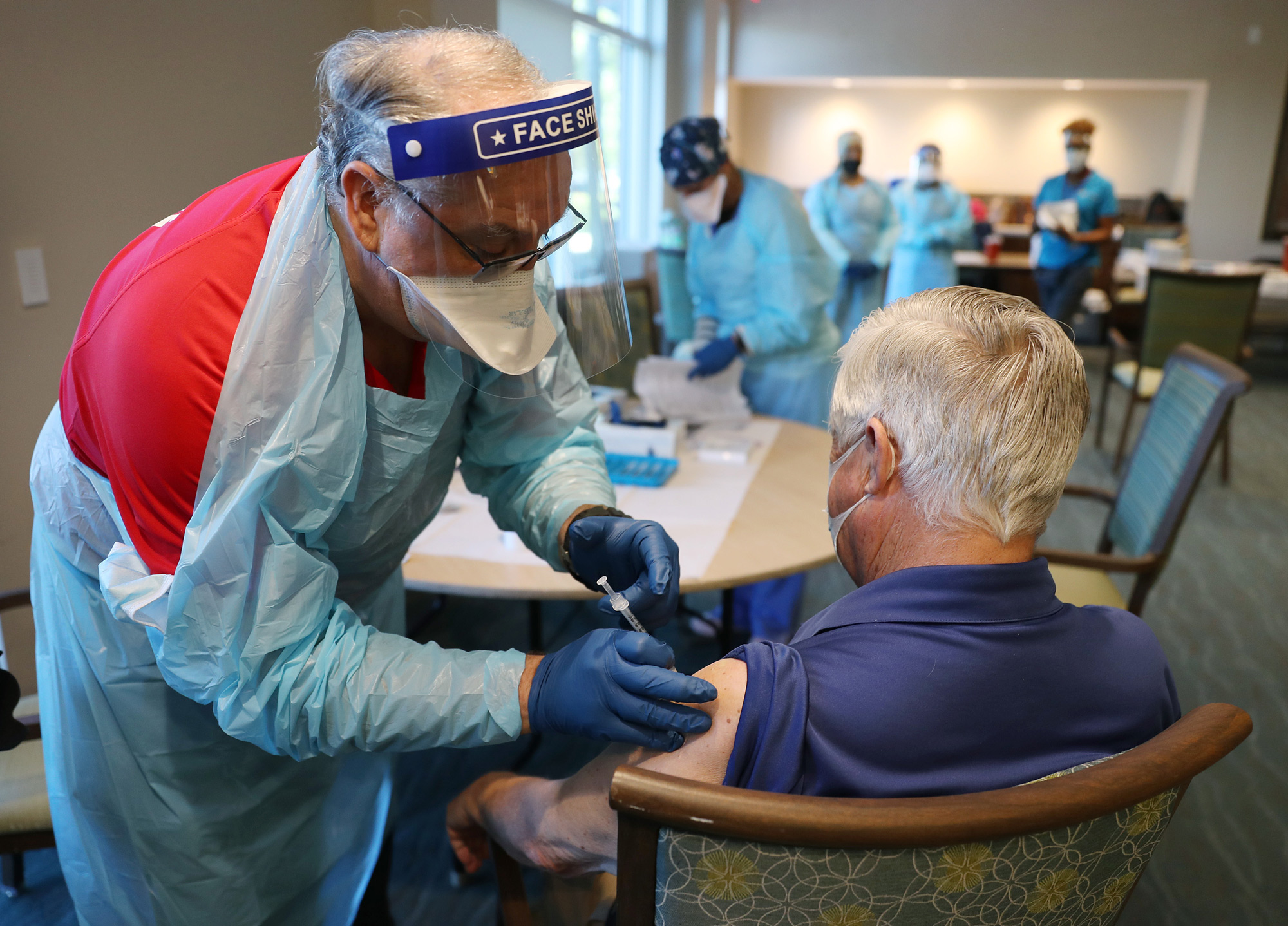 A healthcare worker administers a Pfizer-BioNtech COVID-19 vaccine at the John Knox Village Continuing Care Retirement Community on January 6 in Pompano Beach, Florida. 