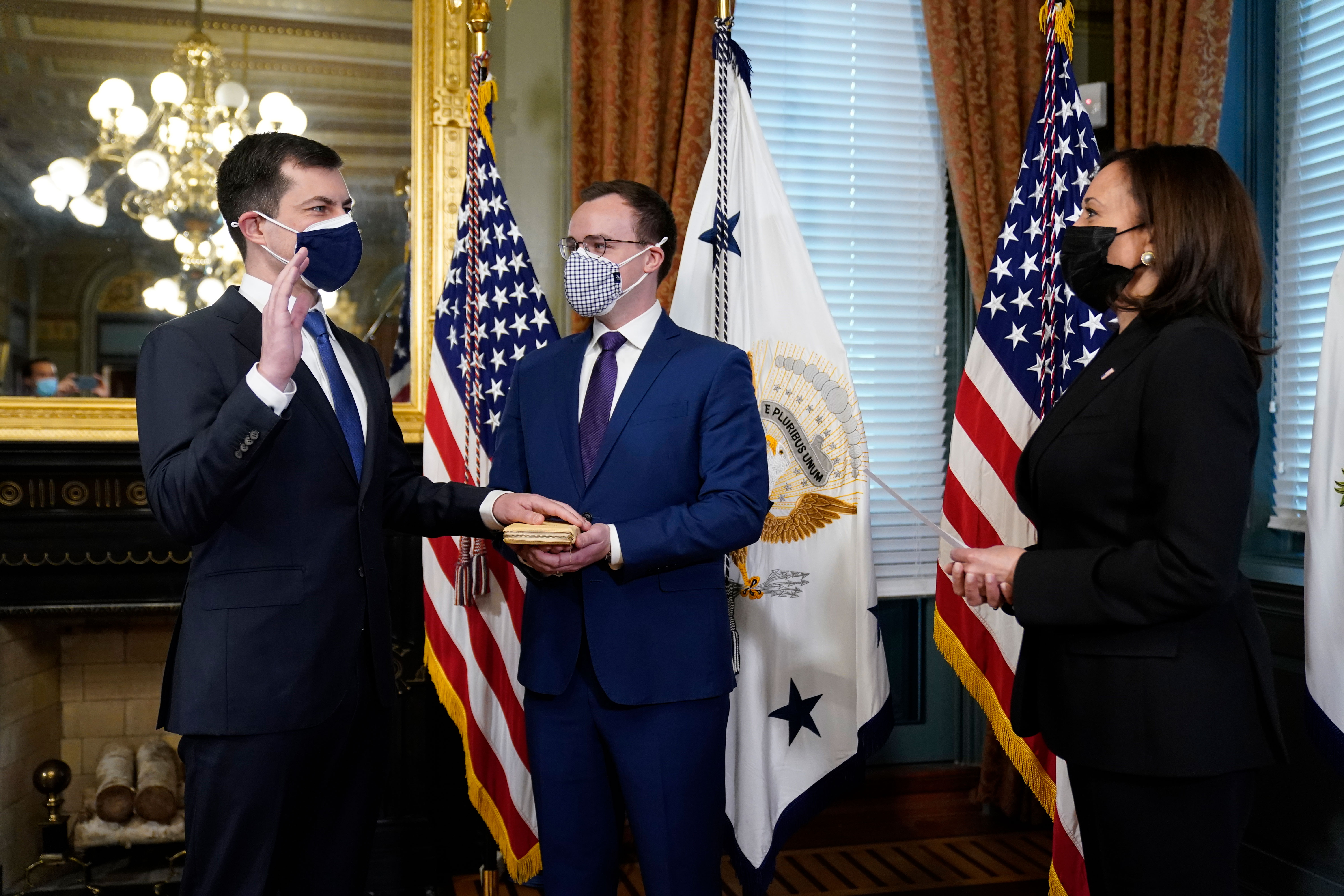 Pete Buttigieg, with his hand on a Bible held by his husband Chasten Buttigieg, is sworn in as transportation secretary by Vice President Kamala Harris in Washington, DC, on February 3.