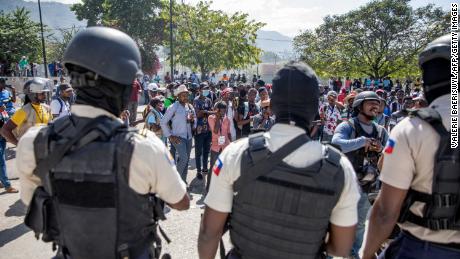 Journalists face armed police as they gather outside the Departmental Directorate of Police to file a complaint after they were hit with tear gas in Port-au-Prince, February 10, 2021. 