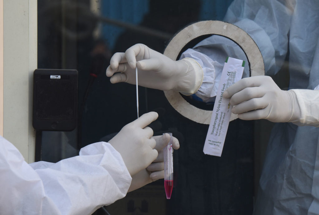 Healthcare workers collect swab samples at a Covid-19 testing and vaccination center at Rajiv Gandhi Super Specialty Hospital on January 12 in New Delhi, India.