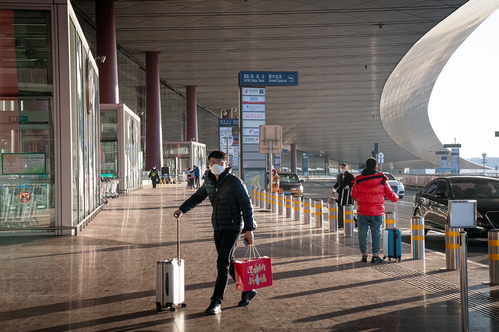 A traveler wearing a protective mask walks toward Beijing Capital International Airport ahead of the Lunar New Year in Beijing, on February 2.