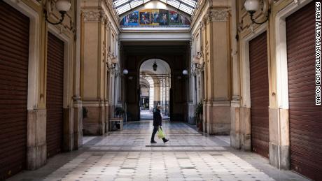 A man wearing a face mask walks across the Galleria Umberto I on March 17, 2021 in Turin during a new lockdown in response to the Covid-19 pandemic.