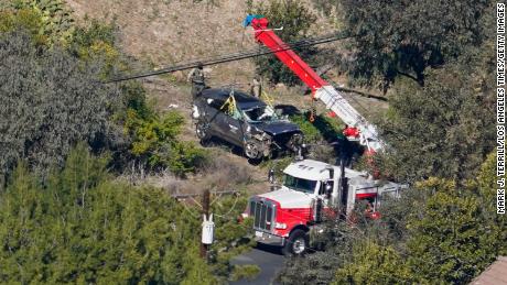 Workers move a vehicle after a rollover accident involving Tiger Woods on February 23, 2021