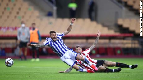 Inigo Martinez of Athletic Bilbao tackles Portu of Real Sociedad which leads to a penalty decision and a red card which was then overturned to a yellow card by VAR during the Copa del Rey final.