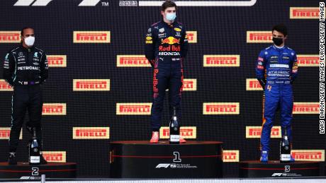 Lewis Hamilton, Max Verstappen and Lando Norris stand on the podium.