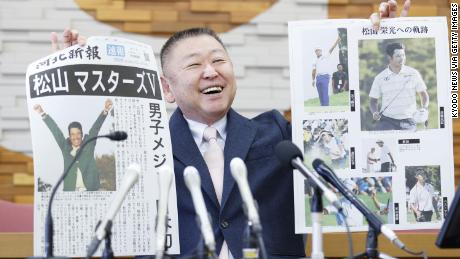 Yasuhiko Abe, who coached golfer Hideki Matsuyama during his Tohoku Fukushi University years, holds special editions of newspapers featuring Matsuyama&#39;s Masters victory. 