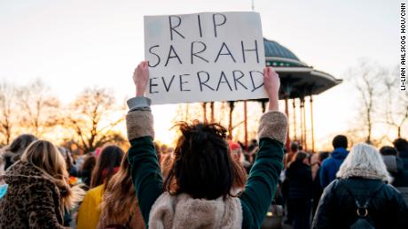 A mourner at the Clapham Common bandstand holds a sign as part of a vigil for Sarah Everard, a 33-year-old woman, whose killing has reignited a national debate on women&#39;s safety and sexual assault.