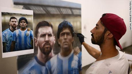 Artist Maximiliano Bagnasco shows off his painting of Diego Maradona.
