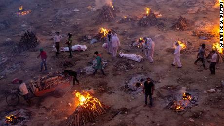 People wait to cremate bodies at a crematorium ground in New Delhi on April 23. 