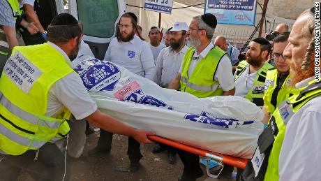 Israeli rescue teams carry a body into an ambulance on Friday at Mount Meron. 