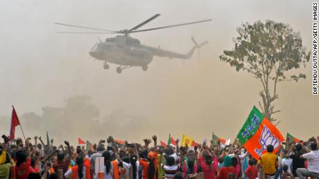 Supporters of Modi&#39;s Bharatiya Janata Party (BJP) wave towards a helicopter carrying the prime minister as he arrives at a rally on April 10. 