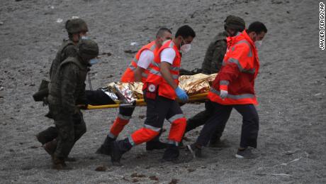 A man is taken on a stretcher by members of the emergency services  and the Spanish army.