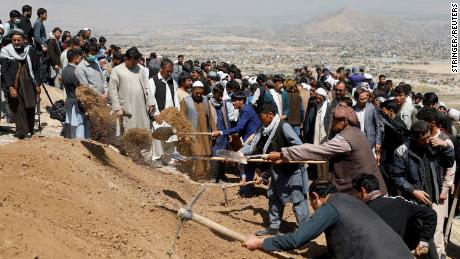 Men dig graves for the victims of Saturday&#39;s explosion during a mass funeral ceremony in Kabul.