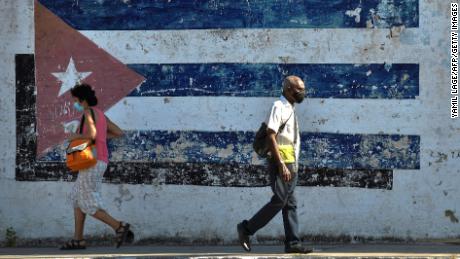 People walk near a mural depicting a Cuban flag in Havana, on April 16, 2021.