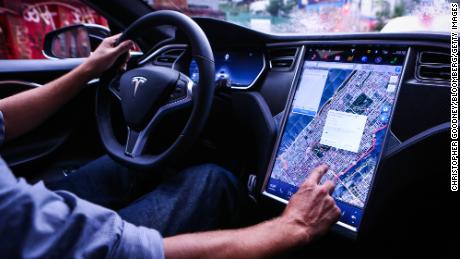 A driver uses the map navigation feature on a touchscreen control panel just prior to the Tesla Motors 8.0 software update inside a Model S P90D.
