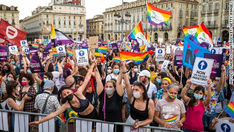 People hold placards and rainbow flags during a demonstration in support of the Zan law in Turin, Italy, on June 5.