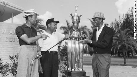 Sifford is presented with the North-South Negro Golf Tournament trophy by night club celebrity Nat &quot;King&quot; Cole. 