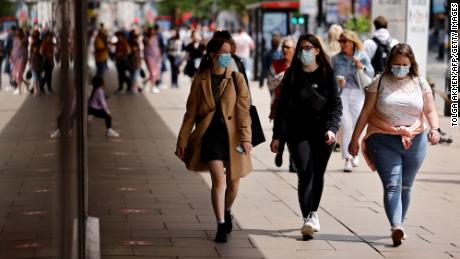 Pedestrians wear face masks while walking along Oxford Street in central London on June 6.