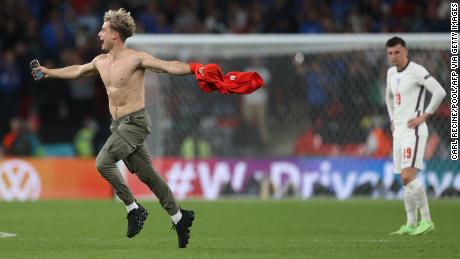 A pitch invader gestures as he runs on the pitch during the Euro 2020 final.