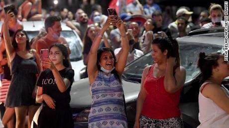 People celebrate in the street after Tunisian President Kais Saied announced the dissolution of parliament and Prime Minister Hichem Mechichi&#39;s government in Tunis on July 25, 2021.