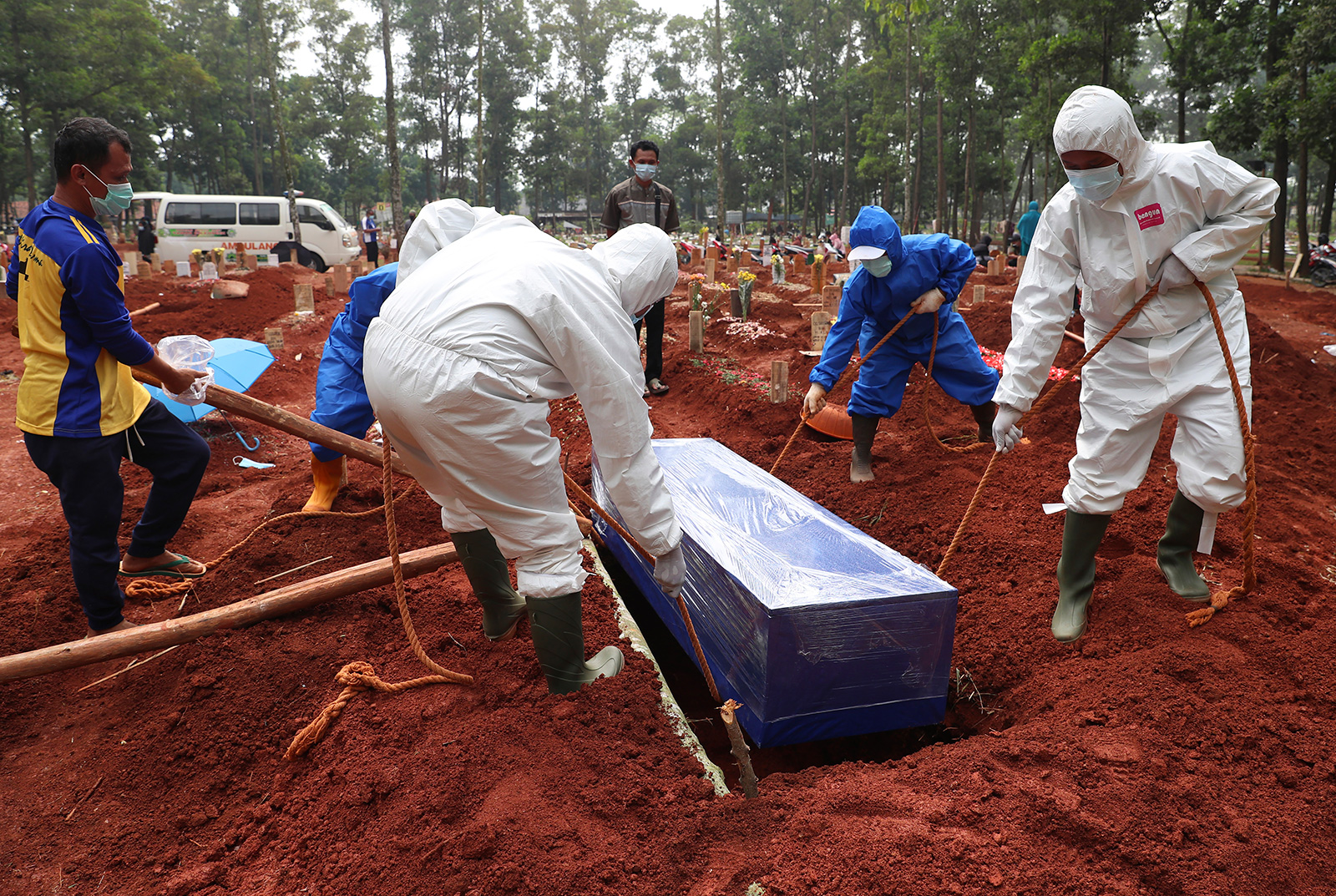 Workers in protective gear lower a coffin of a Covid-19 victim to a grave for burial at the Cipenjo Cemetery in Bogor, West Java, Indonesia, on Wednesday, July 14.