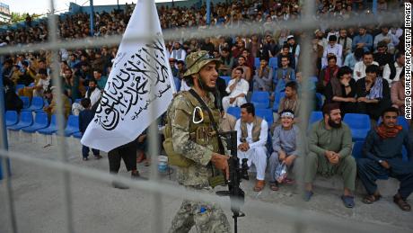 A Taliban fighter keeps vigil as spectators watch the Twenty20 cricket trial match being played between two Afghan teams &#39;Peace Defenders&#39; and &#39;Peace Heroes&#39; at the Kabul International Cricket Stadium in Kabul on September 3, 2021.