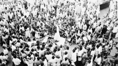 Nigerians crowd around Ali as he rides to his hotel in Lagos on June 1, 1964. Ali led the crowd in cheering himself as &quot;King of the World.&quot; 